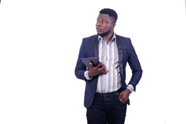 Takım elbiseli genç ciddi işadamı elinde dijital tabletle yan tarafa bakıyor..