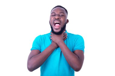 Mavi tişört giyen, boğazı ağrıyan ve elleriyle boynunu tutan genç adamın portresi..