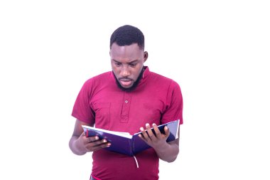 Ciddi bir genç adamın portresi, kırmızı bir tişört giymiş, elinde defterini okuyor..