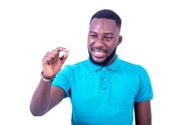 Beyaz arka planda duran mavi tişörtlü genç adam gülümserken iyi bir jest yapıyor..