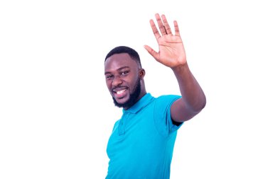 Mavi tişört giyen yakışıklı bir gencin portresi, elini kaldırıyor ve kameraya gülümsüyor..