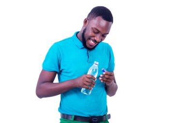 Mavi tişört giyen yakışıklı genç adam elinde bir şişe maden suyu ile gülümsüyor..