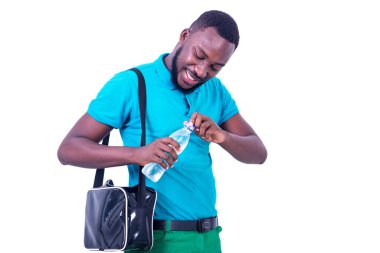 Torbası omzunda yakışıklı genç adam, bir şişe maden suyunu açarken gülümsüyor..