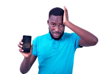 Yakışıklı, hayal kırıklığına uğramış genç bir adam cep telefonu ekranını gösteriyor..