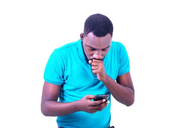 Eli ağızda cep telefonu ekranına bakan yakışıklı bir gencin portresi..