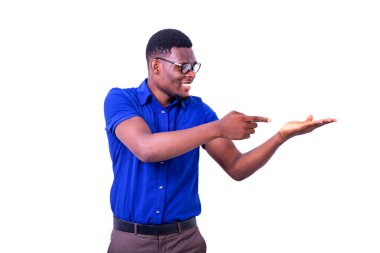 Optik gözlük takan genç ciddi işadamı gülümserken boş avuç içini işaret ediyor..