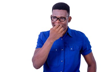 Optik gözlük takan ve elleri ağızda olan genç bir adam..