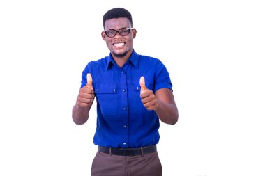 Kameraya gülümserken başparmaklarını gösteren optik gözlük takan genç mutlu bir adam..