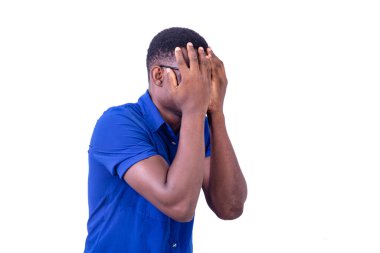 Optik gözlük takan genç bir adamın portresi, elleriyle yüzünü kapatıyor..