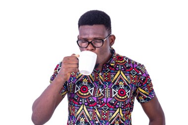 Gözlüklü yakışıklı genç bir işadamı beyaz arka planda kahve içiyor.