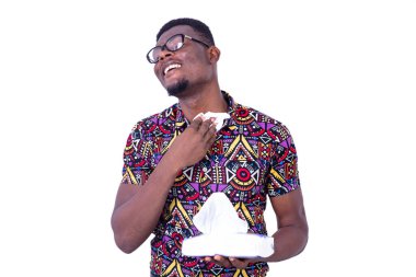 Gözlüklü yakışıklı genç bir işadamı beyaz arka planda durup, mendille boynunu siliyor.