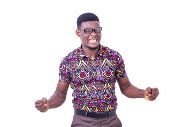 Optik gözlük takan öfkeli genç adam, kaldırılmış yumruklar ve sıkılmış dişlerle ayakta duruyor..