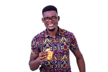 Beyaz arka planda duran gözlüklü yakışıklı genç bir işadamı elinde kruvasanla kameraya bakıp gülümsüyor.