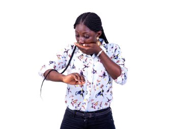 Güzel, genç, şaşkın bir kadının portresi. Elle ağzını kapatırken bileğine bakıyor..