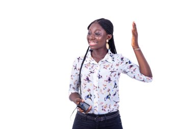 Gülümserken elini kaldıran cep telefonlu güzel bir genç kadının portresi..