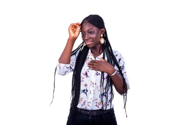 Beyaz bir arka planda duran at kuyruklu genç bir kadın kafasını tutarak düşünürken.