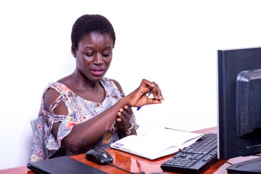 Güzel, genç, ciddi bir iş kadını. Ofiste kol saatini kontrol ediyor..