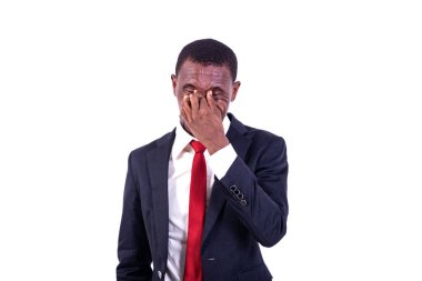 Beyaz arka planda duran ceketli bir işadamı yorgun hissediyor..