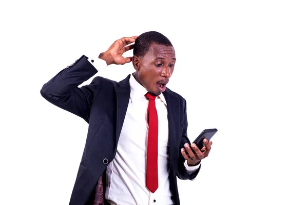 Biznesmen Kurtce Stojący Białym Tle Patrzący Telefon Komórkowy Zaskoczonym Powietrzem — Zdjęcie stockowe