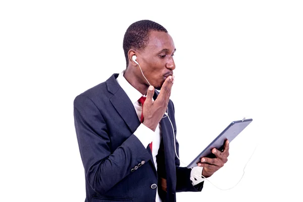タブレットやイヤフォンを使って笑顔でコミュニケーションを取る白地に立つビジネスマン — ストック写真