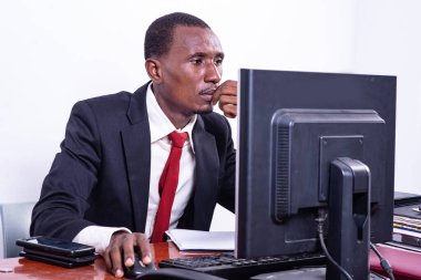 Yakışıklı, ciddi, yetişkin iş adamı ofiste dizüstü bilgisayarla çalışıyor..