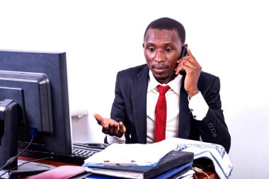 Yakışıklı, ciddi, yetişkin iş adamı ofiste cep telefonuyla konuşuyor..