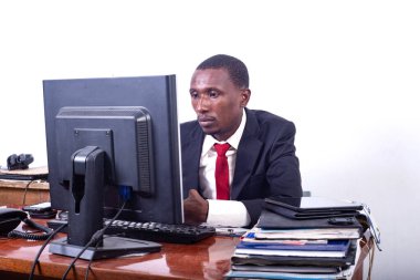 Yakışıklı, ciddi bir iş adamı ofiste dizüstü bilgisayarla çalışıyor..