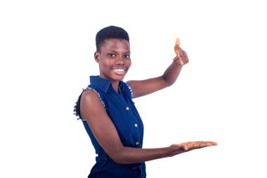 Güzel bir kızın portresi kameraya gülümserken boş avuç içini işaret ediyor..