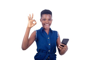 Elinde cep telefonu olan ve kameraya gülümseyen güzel bir genç kadının portresi..