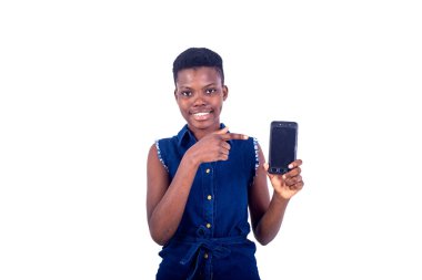 Kameraya gülümserken cep telefonu ekranını gösteren güzel bir genç kadının portresi..