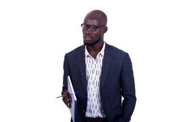 Beyaz arka planda duran ceketli genç bir işadamı elinde bir belge tutarken.