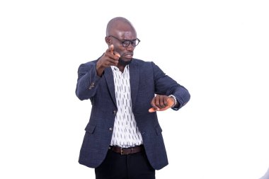 Yakışıklı bir iş adamının portresi kol saatine bakıyor ve parmağını ileri doğru gösteriyor..