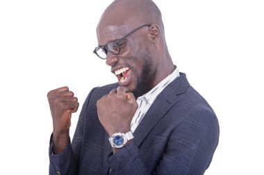 Gri takım elbiseli genç bir işadamı beyaz arka planda durup zafer işareti yapıyor..