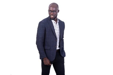 Gri takım elbiseli genç bir işadamı beyaz arka planda duruyor ve gülümseyen bir şeye bakıyor..