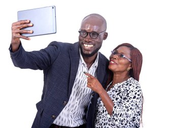 portrait of a smiling businessman and businesswoman taking photo together on a digital tablet.