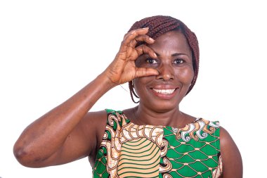 Peştemalli güzel bir kadın beyaz arka planda duruyor. Gözlerinde gülümseme beliren bir jest yapıyor..