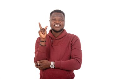 Kameraya gülümserken parmağını kaldıran yakışıklı bir gencin portresi..