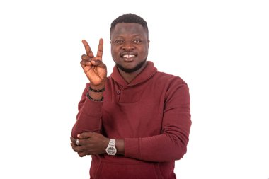 Kameraya gülümserken iki parmağını gösteren yakışıklı bir gencin portresi..