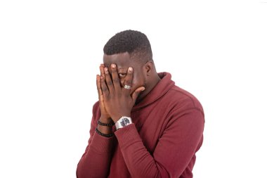 portrait of a handsome fearful young man looking through fingers on face.