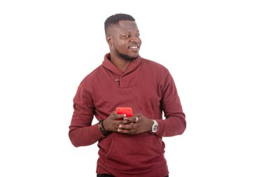 portrait of a handsome young man holding mobile phone and looking aside.