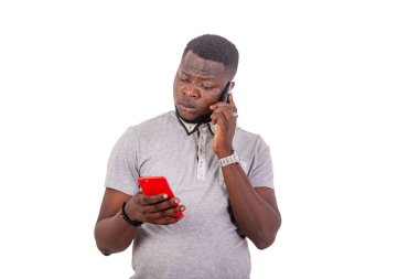 portrait of a serious handsome young man talking on mobile phone and chatting on another mobile phone.
