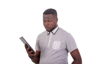 portrait of a handsome disgruntled handsome young man looking at a bad news on his digital tablet.