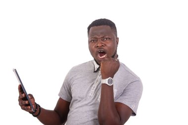 portrait of a handsome young man holding a digital tablet and making a winning gesture with raised hand.