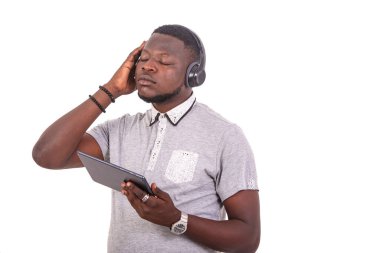 portrait of a handsome young man listening to music with headphones on a digital tablet.