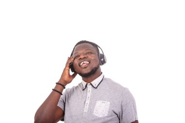 portrait of a handsome happy young man listening to music with headphones on a digital tablet.