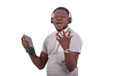 handsome young man listening to music with headphones on a digital tablet.
