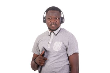 handsome young man listening to music with headphones on a digital tablet.