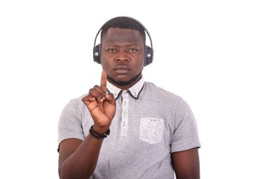 portrait of a handsome serious young man wearing a helmet and raising his finger while looking at the camera.