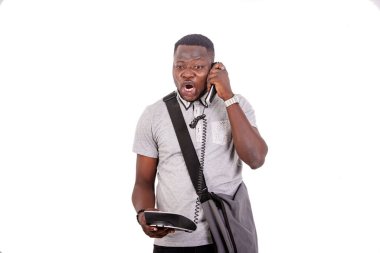 portrait of a disgruntled young male student talking on mobile phone.