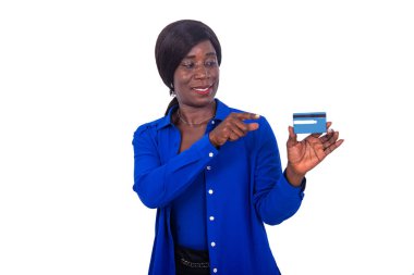 Mavi gömlekli güzel iş kadını beyaz arka planda duruyor ve gülümseyen bir kredi kartı sunuyor..